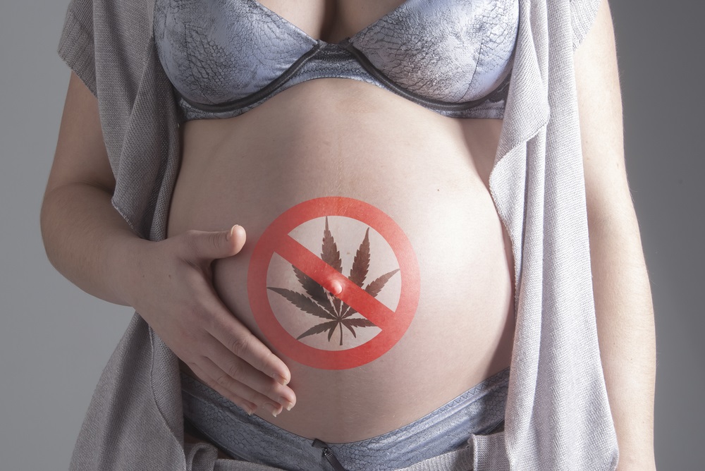 Pregnant woman with sign No marijuana on her belly